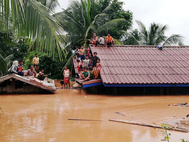 Người dân Lào tập trung trên mái nhà chờ cứu hộ sau sự cố vỡ đập thủy điện (Ảnh: Reuters)
