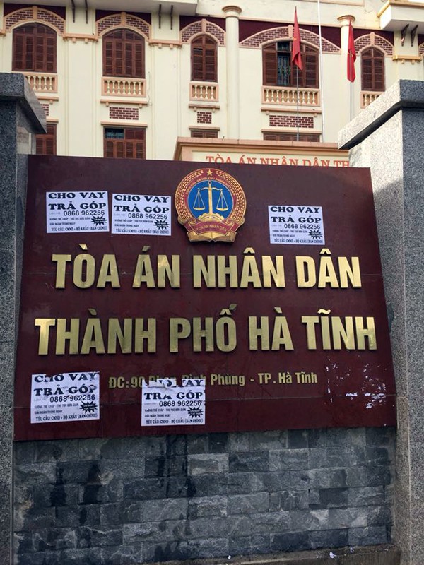 Biển hiệu giới thiệu Tòa án nhân dân TP Hà Tĩnh bị bủa vây các tờ giấy rao vặt cho vay trả góp.
