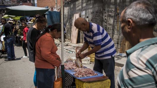 
Một người bán thịt ven đường tại thủ đô Caracas, Venezuela (Ảnh: AFP)
