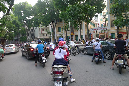 Đối diện trường Tiểu học Trần Quốc Toản, xe của phụ huynh học sinh đón con đỗ kín lòng đường. Hầu hết học sinh vẫn được cha mẹ đưa đón bằng xe máy, ô tô…