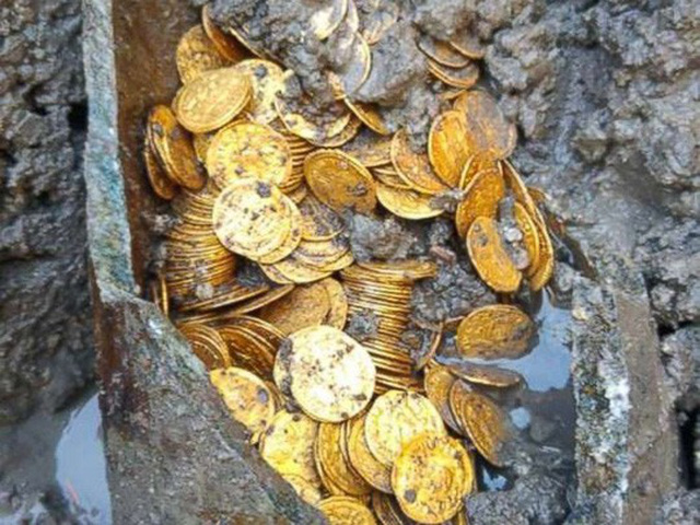 
Các đồng tiền vàng sáng bóng đựng trong một chiếc lọ có 2 tay cầm từ thời La Mã chôn dưới lòng đất. Ảnh: Bộ Văn hóa Ý

