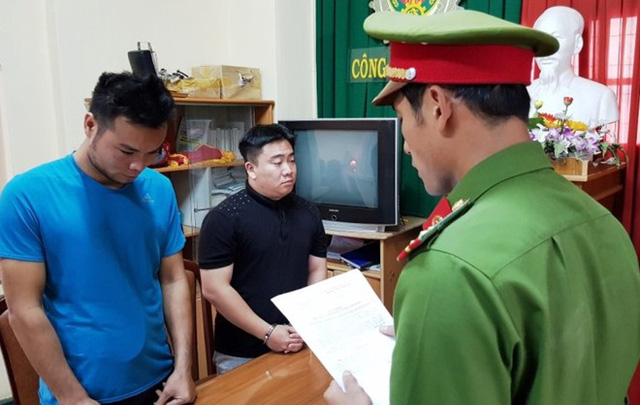 Công an TP Đà Lạt đọc lệnh bắt tạm giam Lê Hải Nam (áo đen) và Lưu Văn Thiện.