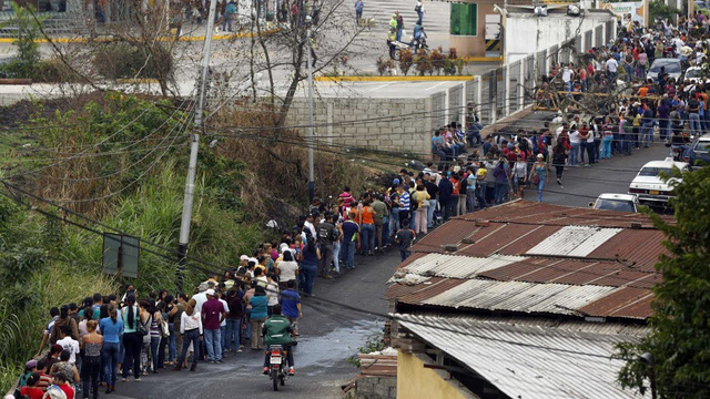 Dòng người xếp hàng trước một cửa tiệm bán bánh mỳ tại Venezuela.