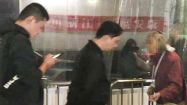 Nhà ga Hàng Châu Đông cảnh báo hành khách không cho tiền bà lão đóng giả ăn xin. (Nguồn: Weibo)