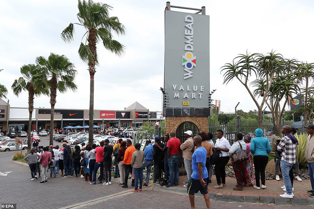Dòng người nối đuôi nhau xếp hàng chờ đợi trước các cửa hiệu ở Johannesburg, Nam Phi. (Ảnh: EPA)