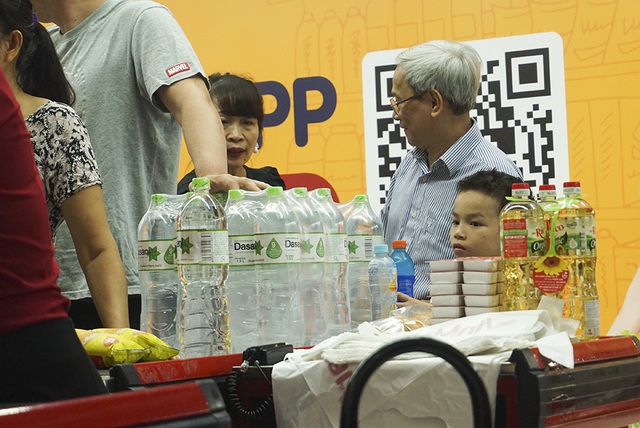 Hà Nội: Người dân ùn ùn đi mua nước đóng chai ở siêu thị - 11