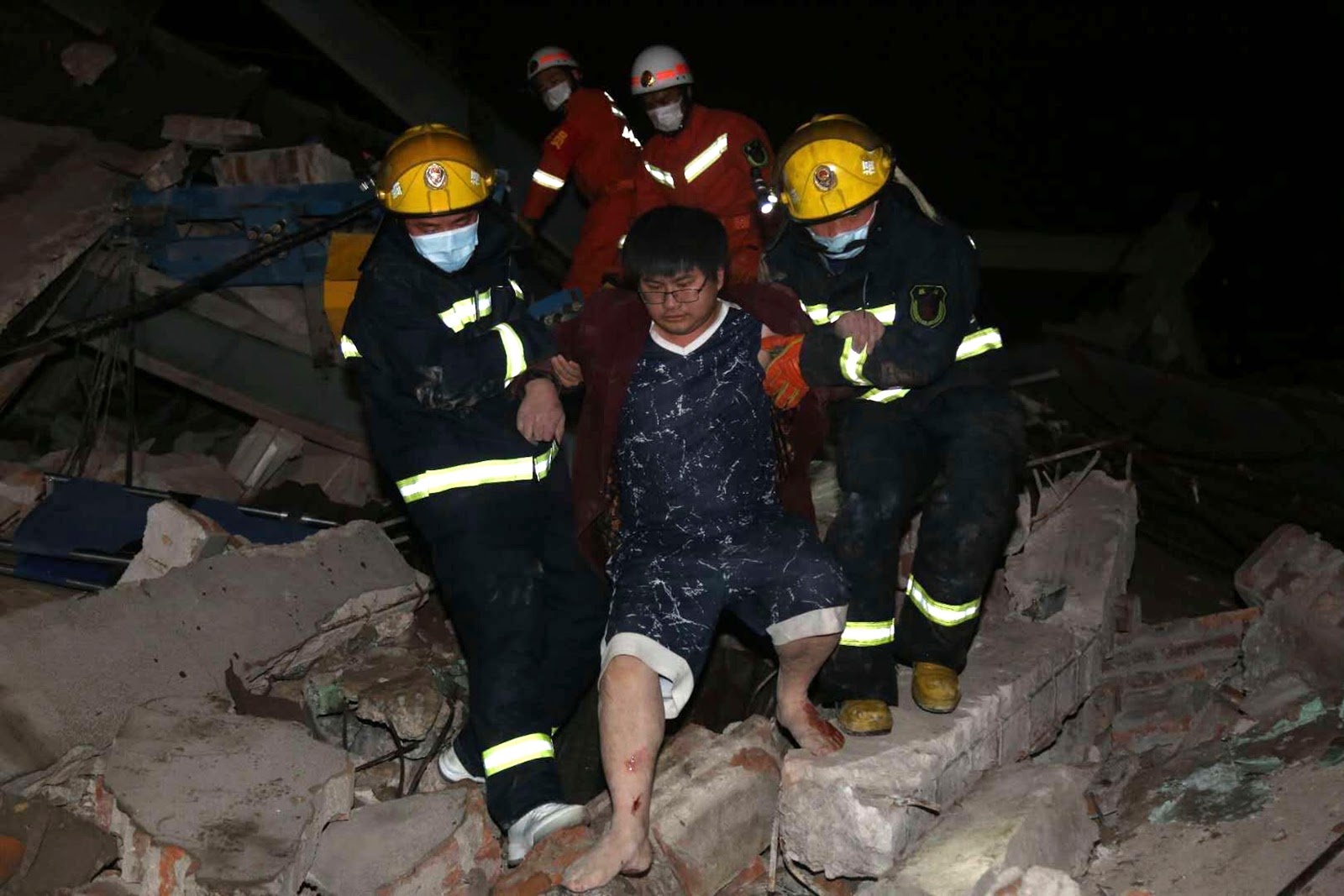  Firefighters rescue a man from the collapsed hotel which was housing quarantined people