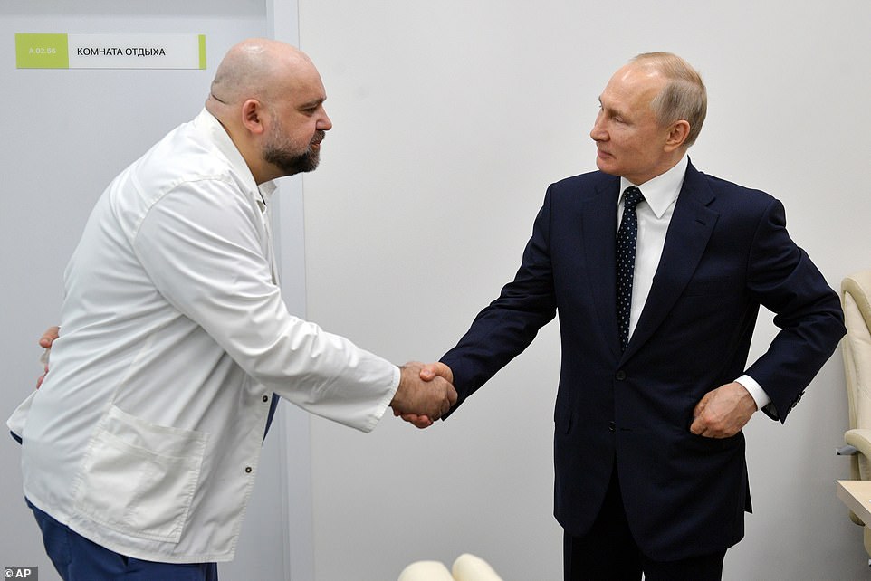 In this file photo taken on Monday, March 23, 2020, Russian President Vladimir Putin, right shakes hands with the hospital's chief Denis Protsenko during his visit to the hospital for coronavirus patients in Kommunarka, outside Moscow, Russia. The chief doctor of Moscow's top hospital for coronavirus patients said last week that he tested positive for the virus