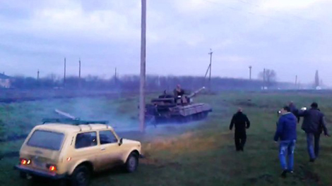 Người biểu tình đối đầu với một xe tăng của quân đội Ukraine.