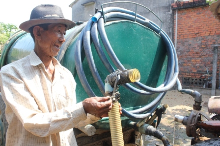 Ông Hưng với chiếc xe công nông, ống dẫn nước và bồn chứa để hành nghề bán nước ngọt