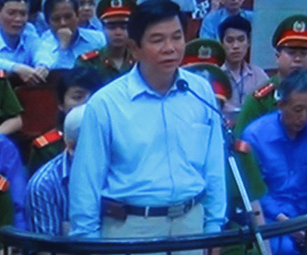 Phạm Trung Cang vẫn đeo bao điện thoại khi đứng dậy trả lời các câu hỏi thẩm tra căn cước