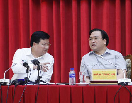 Bộ trưởng Xây dựng Trịnh Đình Dũng trao đổi với Phó Thủ tướng Hoàng Trung Hải tại cuộc họp.
