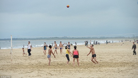 Người dân ra biển dạo mát hoặc chơi bóng chuyền lúc cuối ngày.