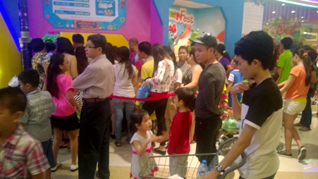Các bé và phụ huynh xếp hàng đợi vào khu vui chơi trong trung tâm mua sắm