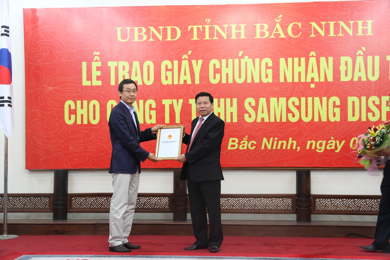 Chủ tịch UBND tỉnh Bắc Ninh (trái) trao giấy chứng nhận đầu tư cho công ty TNHH Samsung Display.
