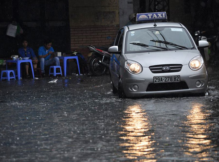 Vỉa hè cũng ngập nước, taxi phải bật đèn pha trên đường.