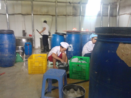 Công nhân nữ đang rửa bình, chai nhựa để tái sử dụng