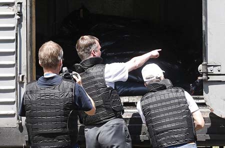 Quan sát viên OSCE kiểm tra các thi thể được chất lên đoàn tàu