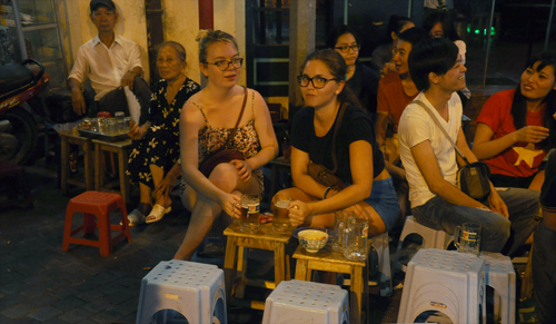 Khách nước ngoài thích thú khi được ngồi uống bia vỉa hè ở phố đi bộ Tạ Hiện