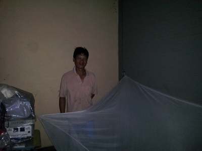 Anh Phạm Văn Huân mắc chiếc màn tạm bợ để nằm ngủ dưới hiên Bưu điện.