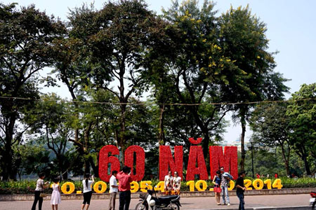 Những biểu ngữ kết bằng hoa rực rỡ khắp phố phường Hà Nội những ngày này.