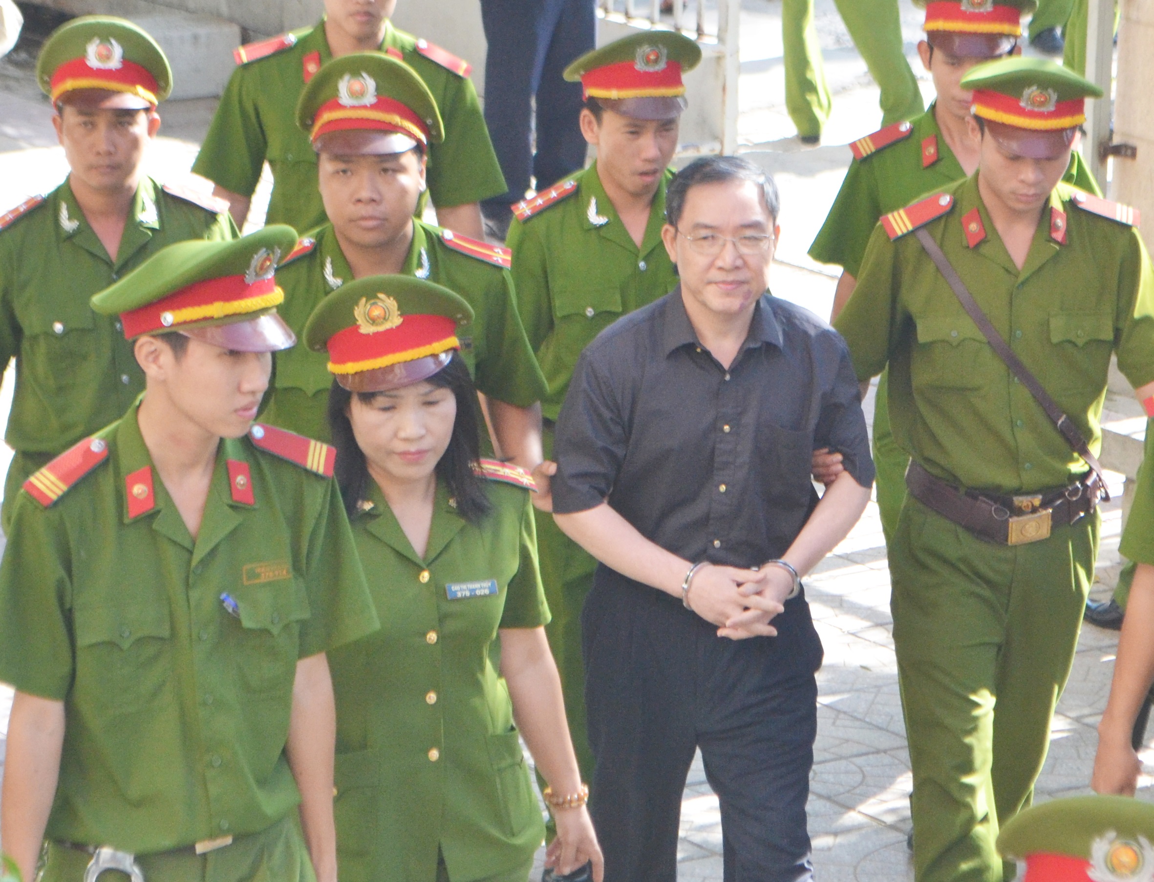 Sơn đang được lực lượng hỗ trợ tư pháp dẫn giải vào TAND tỉnh Khánh Hòa lúc 8h15 sáng nay 11/11.