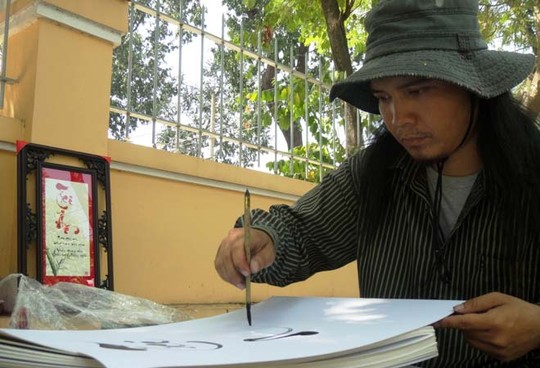Nhiều người chọn mua tranh thư pháp làm quà tặng 20-11. Một điểm vẽ tranh thư pháp ở vỉa hè đường Trương Định (quận 3).