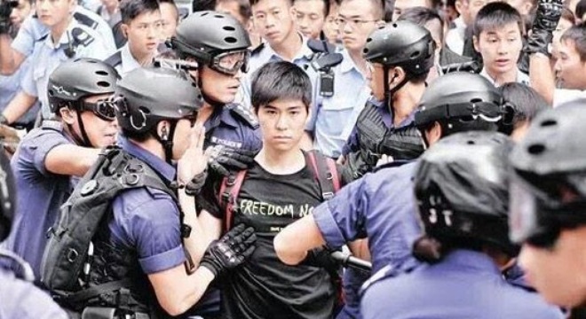 Chàng thanh niên Lester Shum vẫn tỏ ra bình thản khi bị cảnh sát bắt giữ. Ảnh: Twitter