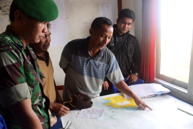 Một quan chức quân đội Indonesia thảo luận với người dân về vụ máy bay mất tích.