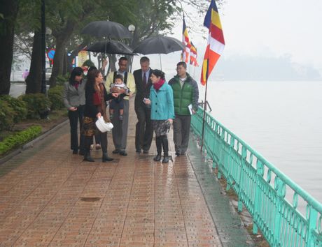 Đại sứ Mỹ và gia đình di dạo bên Hồ Tây trong tiết trời mưa nhỏ. (Ảnh: