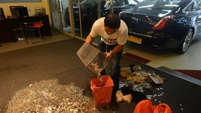 Một nhân viên của cửa hàng thu gom đống tiền xu để trả lại luật sư của anh Ong. 