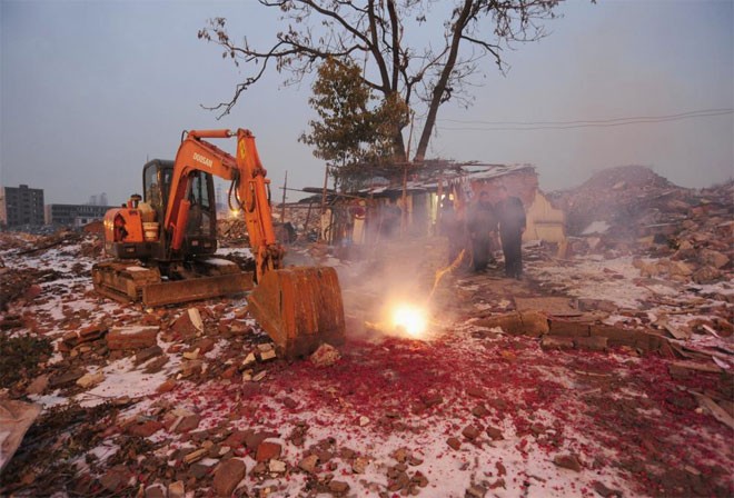 Nhà họ Cao, chủ một “nhà đinh” ở Hợp Phì, An Huy, Trung Quốc đốt pháo đón năm mới hôm 13/2/2013 - Ảnh: Reuters.