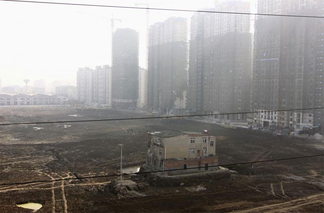“Nhà đinh” nằm trơ trọi giữa một công trường rộng lớn đã giải tỏa xong để chuẩn bị xây dựng một dự án chung cư ở Xiangyang, Hồ Bắc, Trung Quốc ngày 19/11/2013 - Ảnh: Reuters.