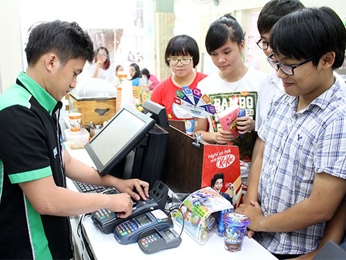 Khách mua hàng thanh toán qua thẻ tại Family Mart trên đường Lê Quý Đôn, quận 3, TP HCM. 
(Ảnh chỉ có tính minh họa) Ảnh: HOÀNG TRIỀU