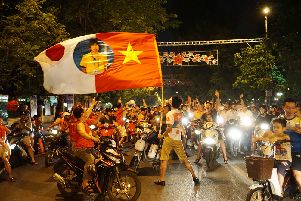 Lá cờ ghép đôi Việt Nam - Nhật Bản cùng HLV Miura bay phất phới trên đường phố.