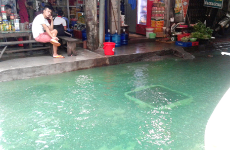 
Dòng nước ngập có màu xanh thẫm lạ lùng trên phố Tam Trinh (quận Hai Bà Trưng, Hà Nội). Thủ phạm sau đó được xác định là 2 bao tải chứa thuốc nhuộm trong nhà kho cũ của một công ty nhuộm. (Ảnh: Quang Phong)
