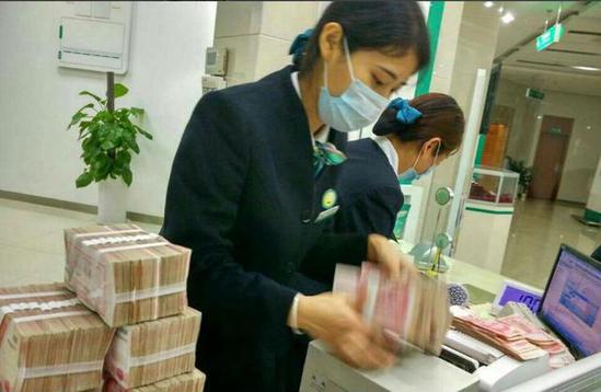 Nhân viên thu ngân tại ngân hàng đang đếm tiền của ông Li