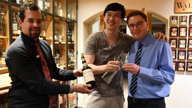 
Nhà văn Zhang Wei (đứng giữa) và chai rượu whisky nhãn hiệu Macallan dỏm được sản xuất vào năm 1878 tại khách sạn Waldhaus am See, Thụy Sĩ. (Nguồn: AFP/ Getty)
