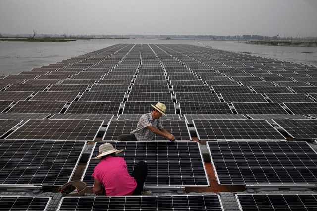 Các công nhân đang chuẩn bị những tấm pin mặt trời để chúng có thể hoạt động tốt nhất. (Nguồn: Kevin Frayer/Getty Images)