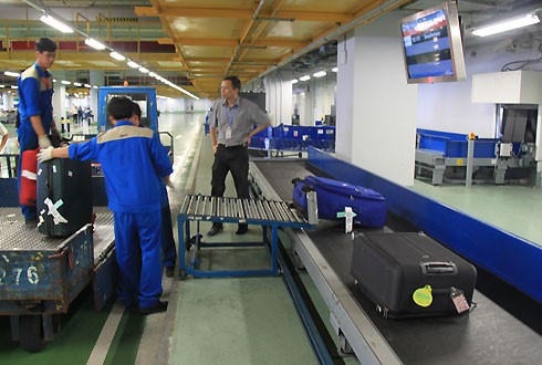 ACV quản lý, khai thác các sân bay dân dụng (ảnh: nhân viên bốc xếp hàng hoá tại sân bay Nội Bài)